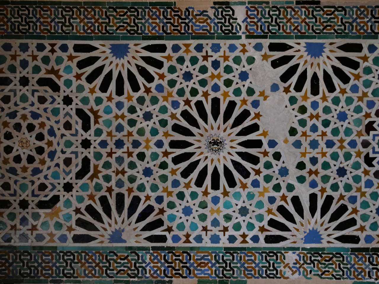 Detailed Islamic tile design featuring geometric motifs in the Alhambra, Granada.